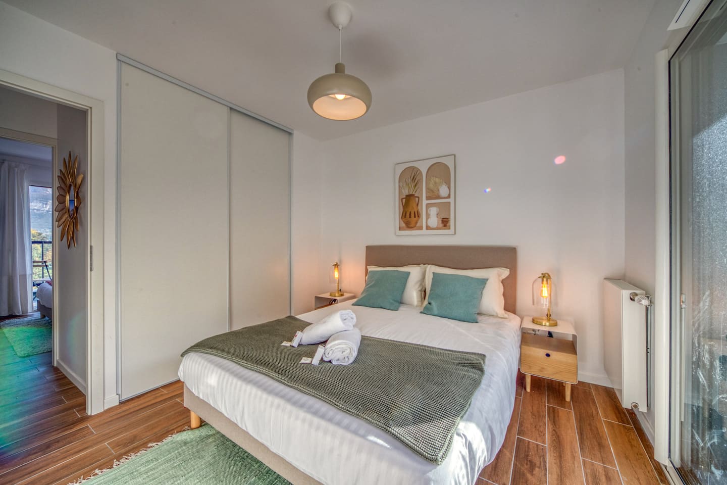 Chambre avec lit double et accès balcon, appartement vue lac en Savoie